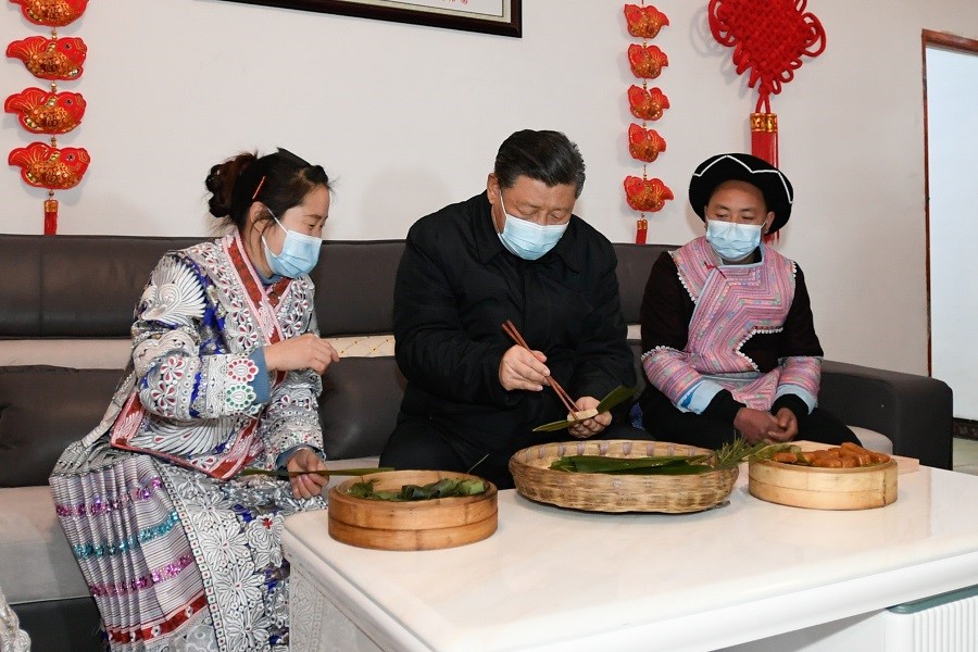 2021年2月3日下午，習(xí)近平在貴州畢節(jié)市黔西縣新仁苗族鄉(xiāng)化屋村苗族村民趙玉學(xué)家，同一家人邊聊家常邊制作當(dāng)?shù)貍鹘y(tǒng)節(jié)日食品黃粑。新華社記者 李學(xué)仁 攝