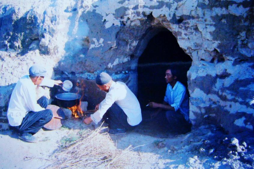 1983年，“六老漢”一代治沙人在“地窩子”生活做飯。新華社發(fā)（八步沙林場供圖）